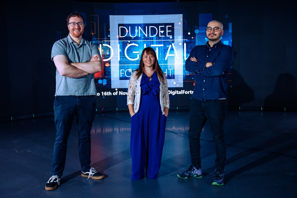 Three people standing in front of DDF logo on a digital screen